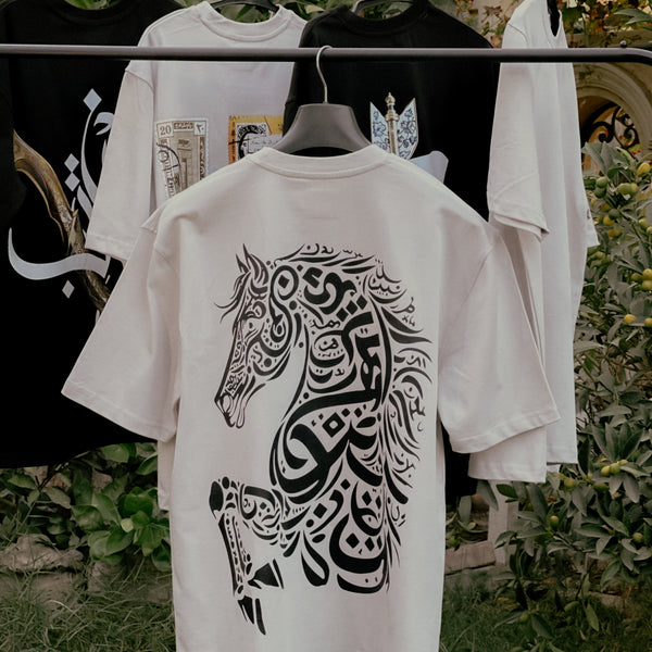 Beige t-shirt with black horse design on a rack outdoors