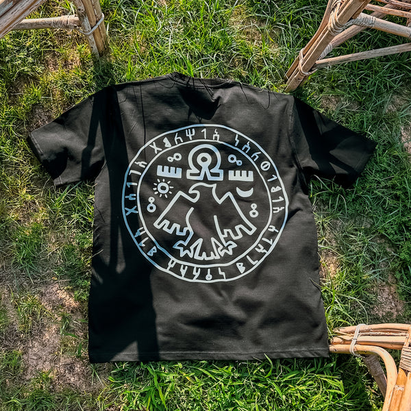 Black t-shirt with white graphic design on grass
