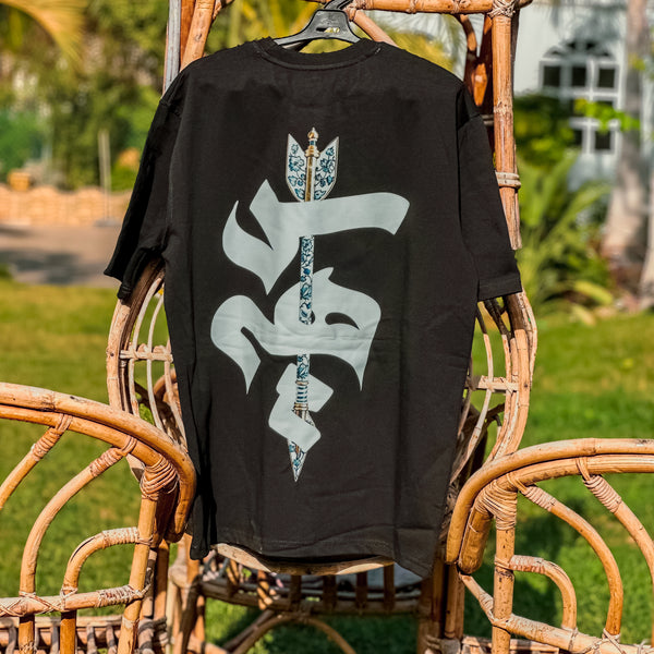 Black sweatshirt with a white symbol on a wicker chair outdoors