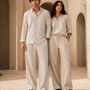 Couple wearing ATHAR Linen Relaxed Fit shirts in offwhite and beige, Cairo heritage archway