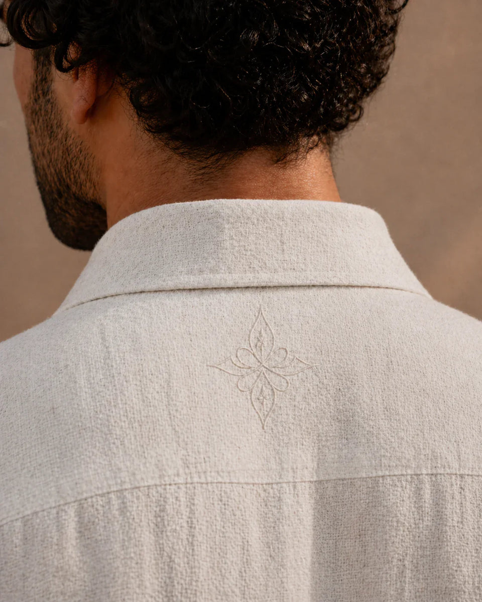 Light gray shirt with a subtle pattern on a neutral background