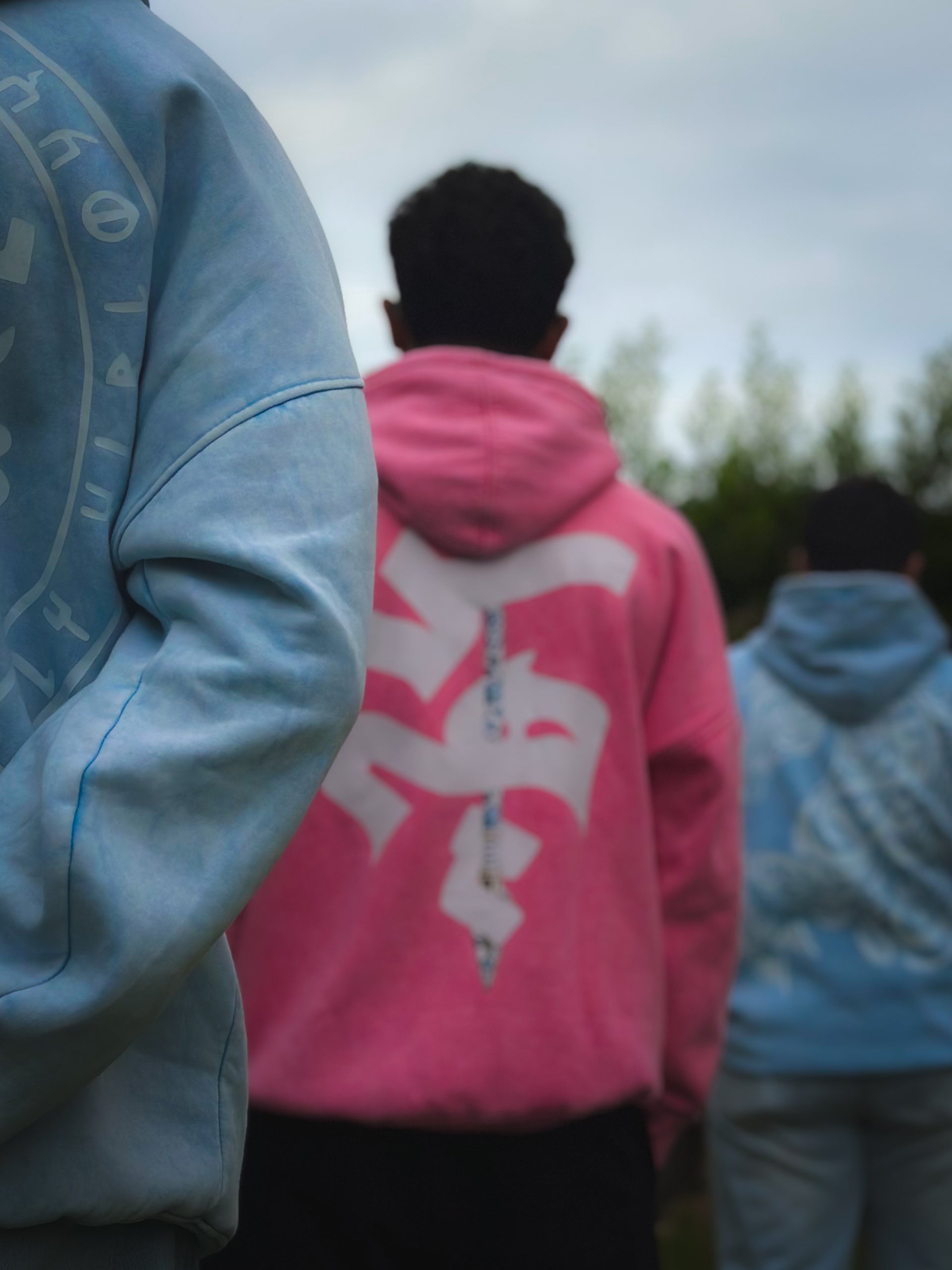  Three people wearing hoodies with a blurred background