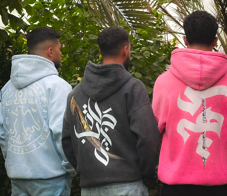  Three people wearing hoodies with visible branding in a forest setting