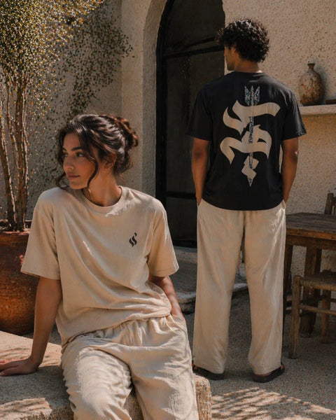 Two people wearing matching outfits with a logo in an outdoor setting.