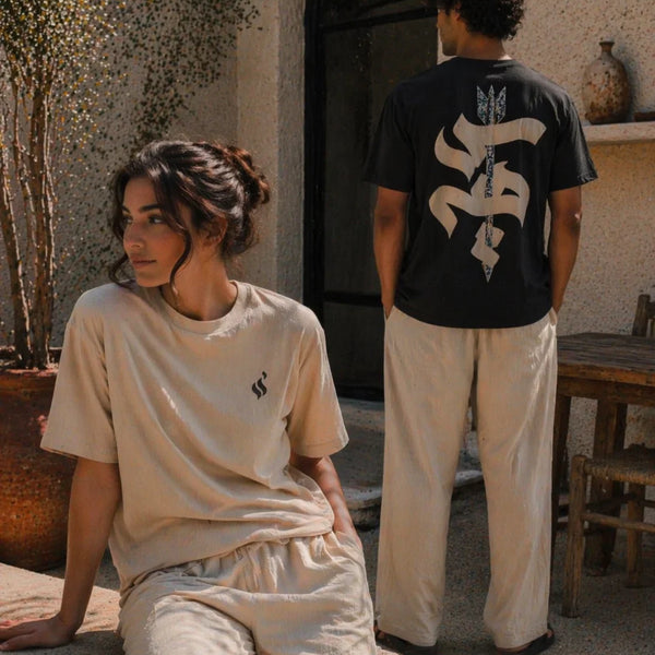 Two people wearing matching outfits with a logo in an outdoor setting.