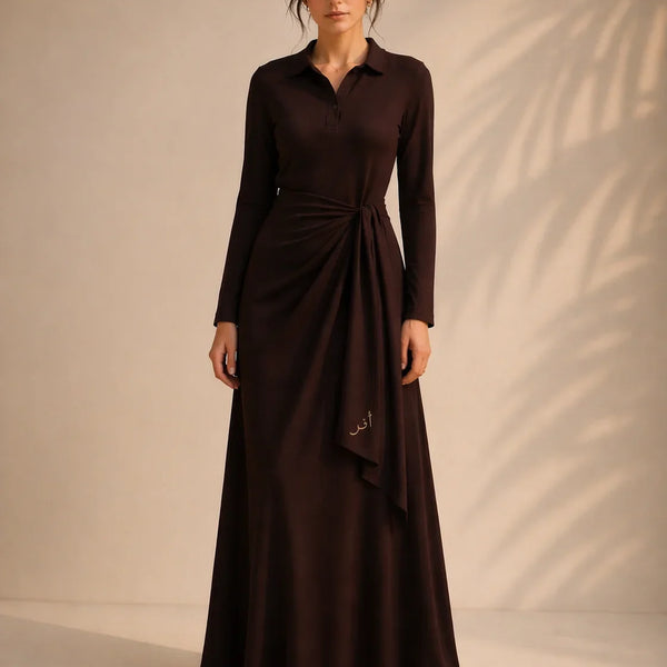 Woman wearing a long brown dress against a beige background