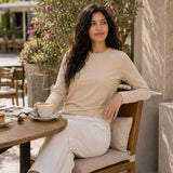 QADIM washed beige long sleeve tee, seated cafe editorial in warm tones