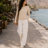 QADIM washed beige long sleeve tee, seaside promenade full look with white trousers