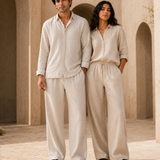 Couple wearing ATHAR Linen Relaxed Fit shirts in offwhite and beige, Cairo heritage archway | زوجان يرتديان قميص أثر الكتان الفضفاض بلوني أوف وايت وبيج أمام قوس أثري في القاهرة