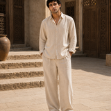 Man in ATHAR Linen Relaxed Fit Beige shirt in front of carved wooden doors, Cairo | رجل بقميص أثر الكتان الفضفاض البيج أمام باب خشبي منقوش بالقاهرة