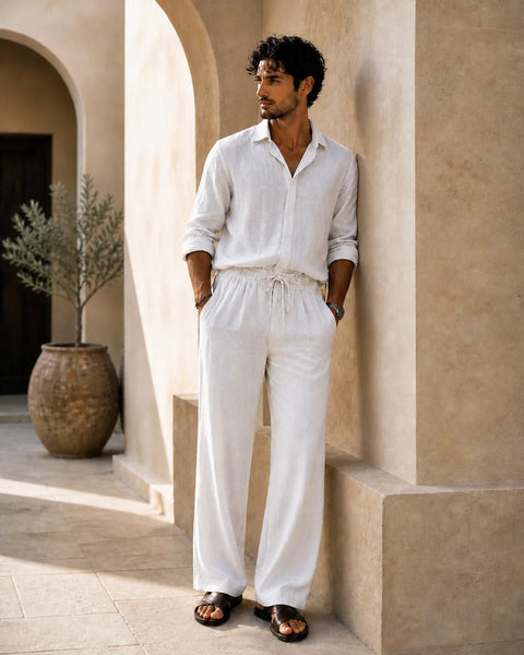 QADIM ATHAR Linen Trousers in off-white styled on male model in warm Mediterranean setting