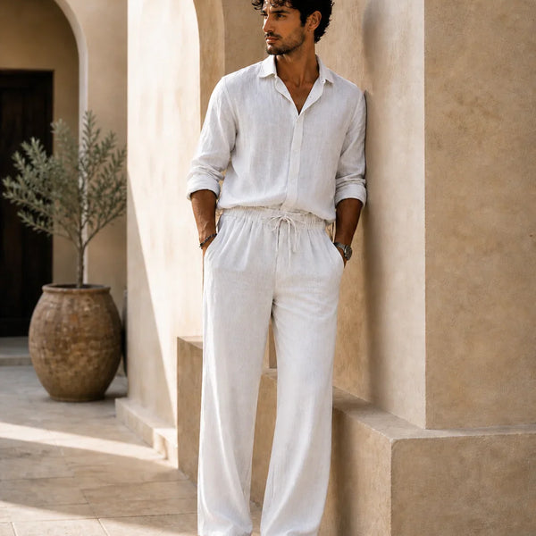 QADIM ATHAR Linen Trousers in off-white styled on male model in warm Mediterranean setting