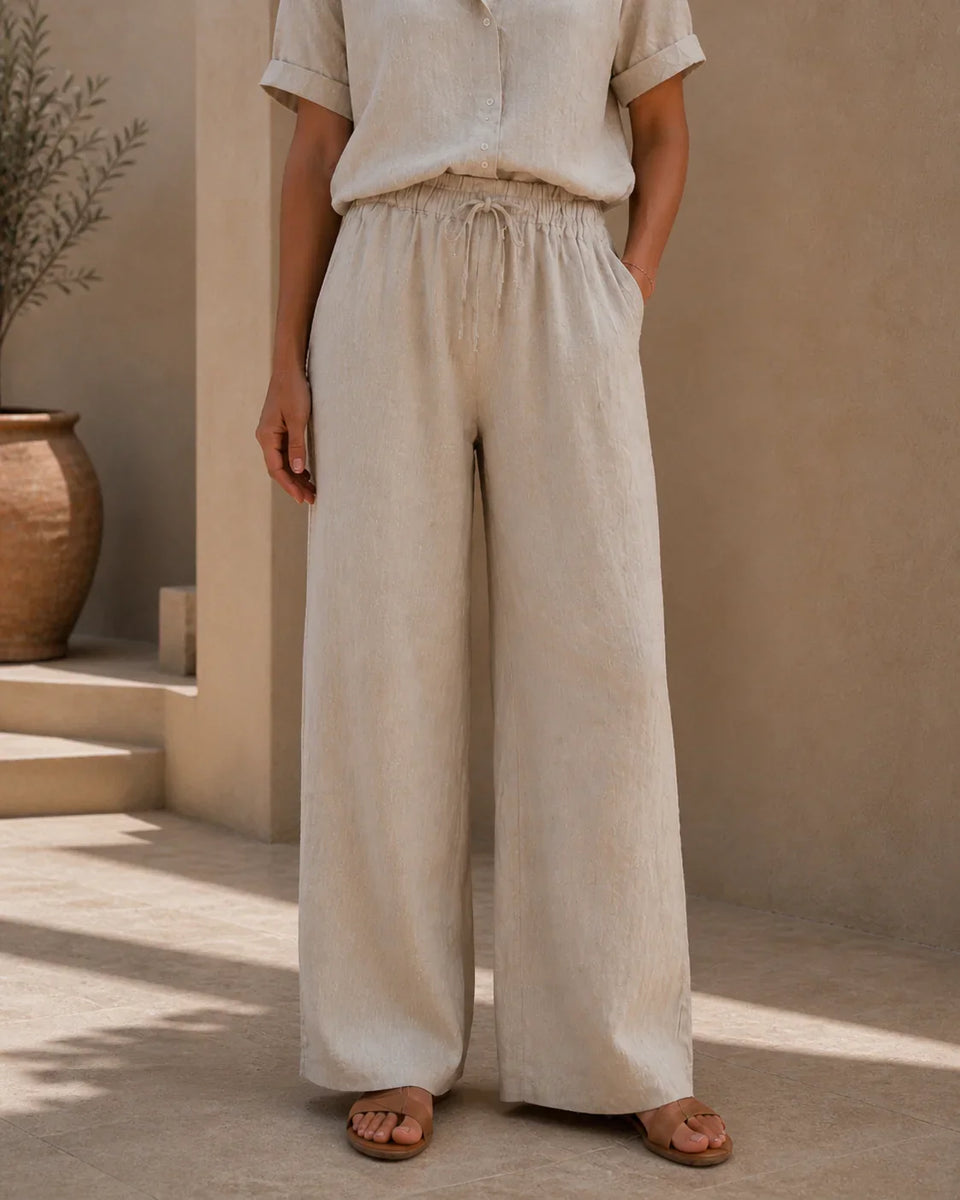 Front detail of QADIM sand linen trousers showing elastic waistband, drawstring, and wide-leg silhouette