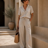 QADIM ATHAR Linen Trousers in sand styled on female model with matching linen shirt