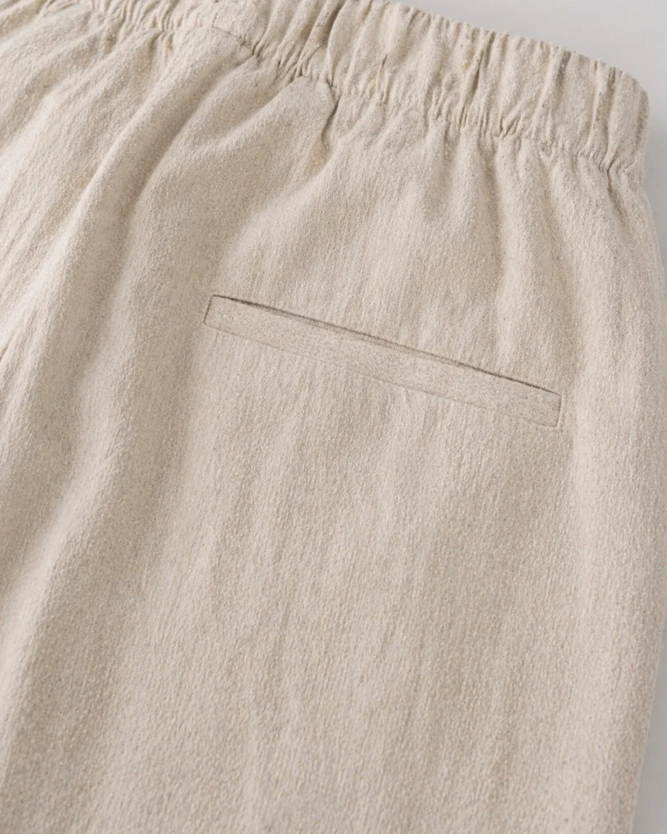Beige pants with an elastic waistband on a light gray background