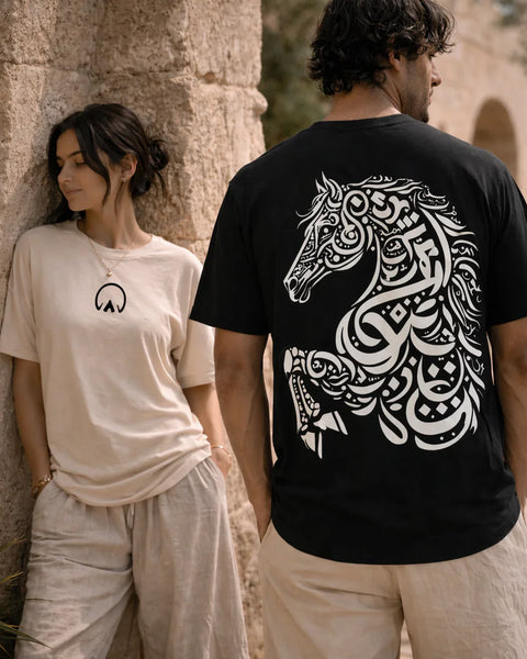 Two people wearing t-shirts with a horse design and abstract symbol.