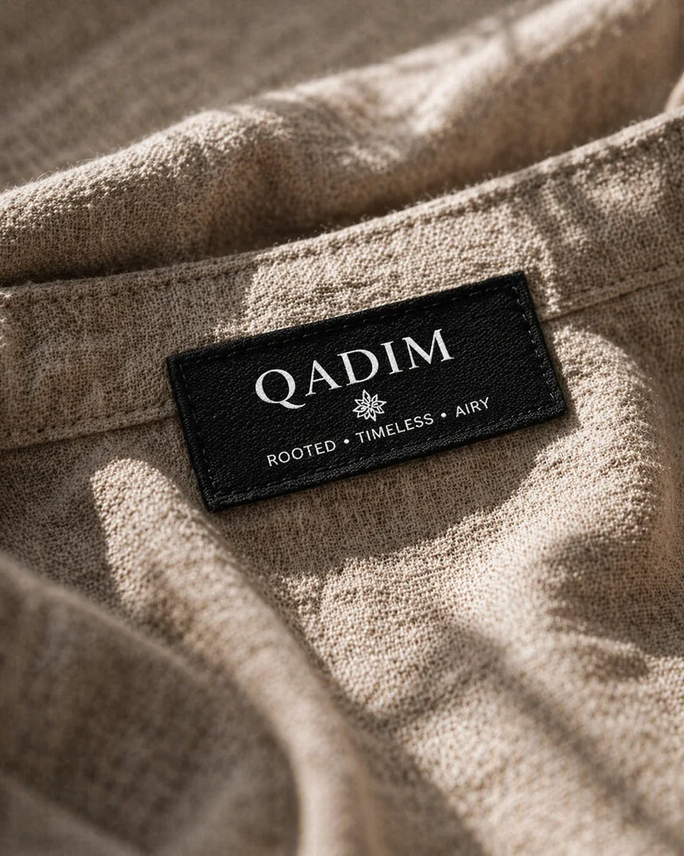 QADIM label on a textured fabric background