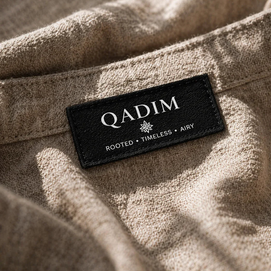 QADIM label on a textured fabric background