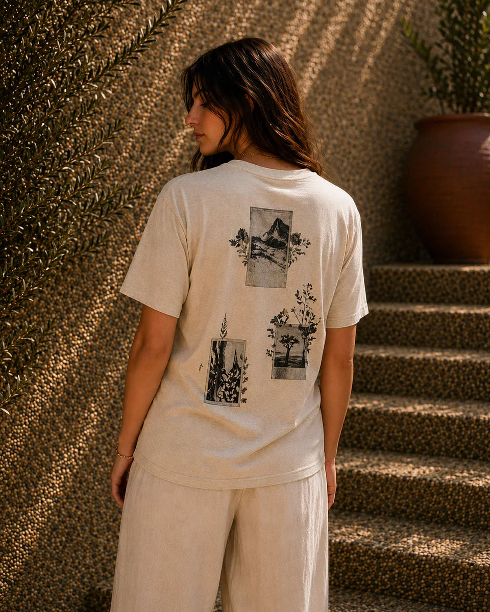 QADIM Naqsh beige half sleeve tee back artwork worn by female model beside stone stairs