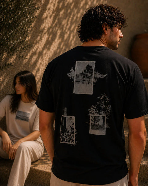 QADIM Naqsh half sleeve tee in black and beige worn by male and female models in a sunlit Mediterranean setting