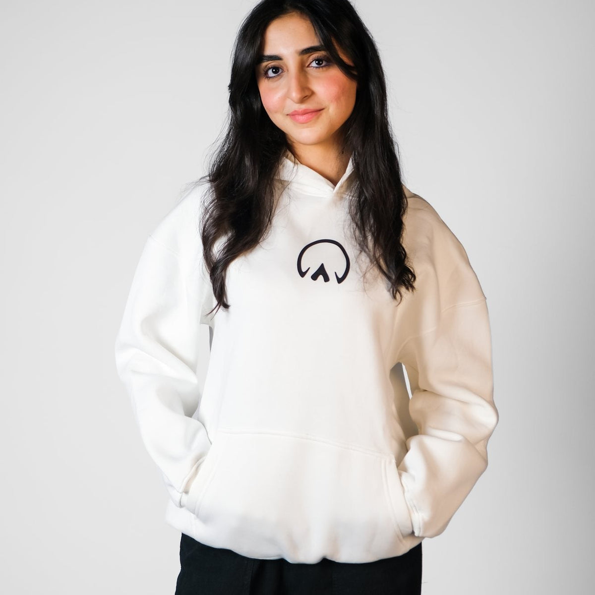 QADIM Asil relaxed hoodie in white worn by female model, front | هودي الأصيل ريلاكس أبيض على موديل بنت