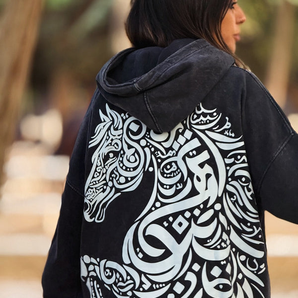 QADIM Asil washed hoodie in black, calligraphy horse back print up close, with Arabian horses — @marwaabuelezz | ضهر هودي أصيل المغسول الأسود