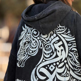 QADIM Asil washed hoodie in black, calligraphy horse back print — worn by @marwaabuelezz | هودي أصيل مغسول أسود