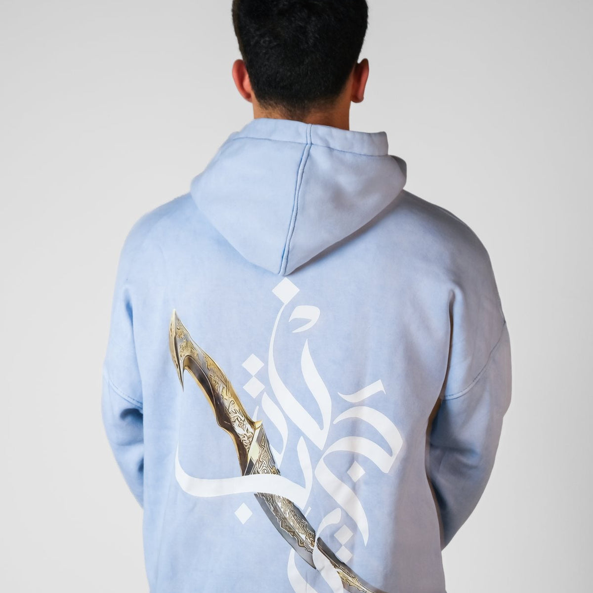 QADIM Jambiya washed hoodie in baby blue, back print, male model | هودي جنبية مغسول بيبي بلو على موديل ولد