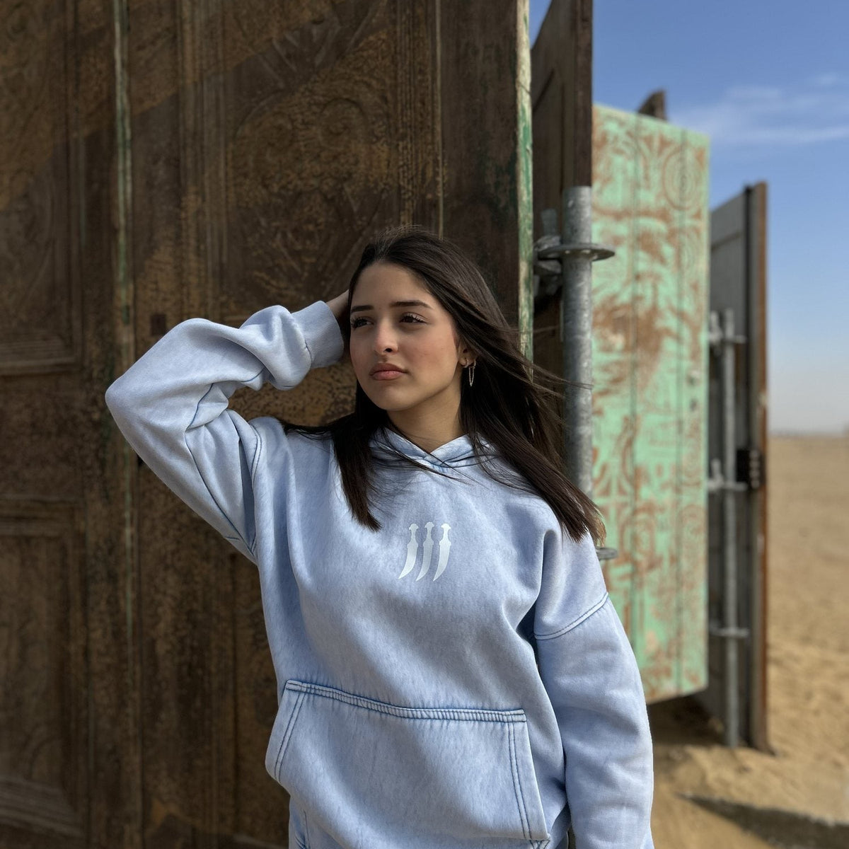 QADIM Jambiya washed hoodie in baby blue, front, desert doors | هودي جنبية مغسول بيبي بلو في الصحرا