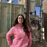 QADIM Jambiya washed hoodie in rose, front, old wooden doors in the desert | هودي جنبية مغسول روز قدام الأبواب القديمة