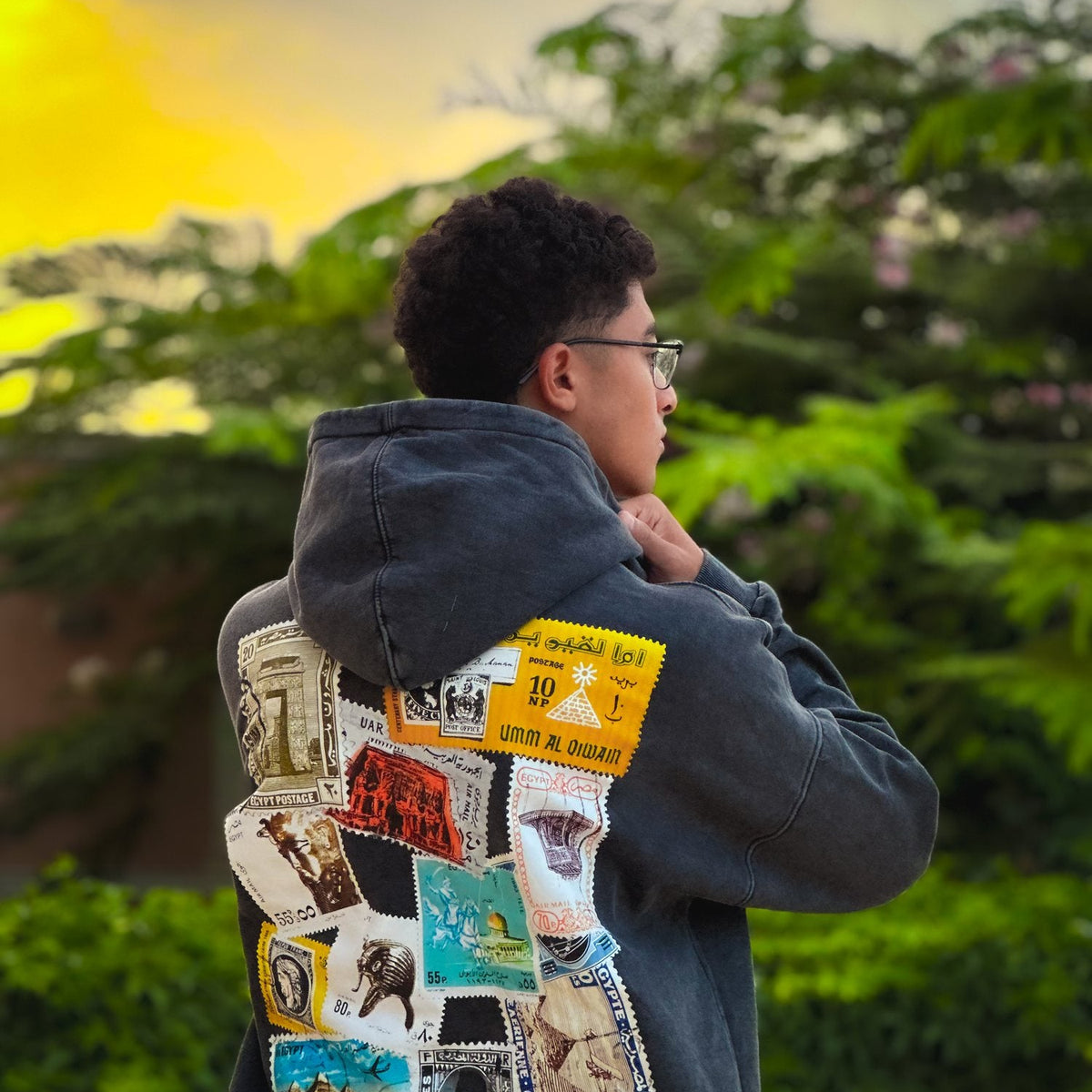 QADIM Tawabie washed hoodie in black, stamps back print, golden hour garden | هودي طوابع مغسول أسود وقت الغروب