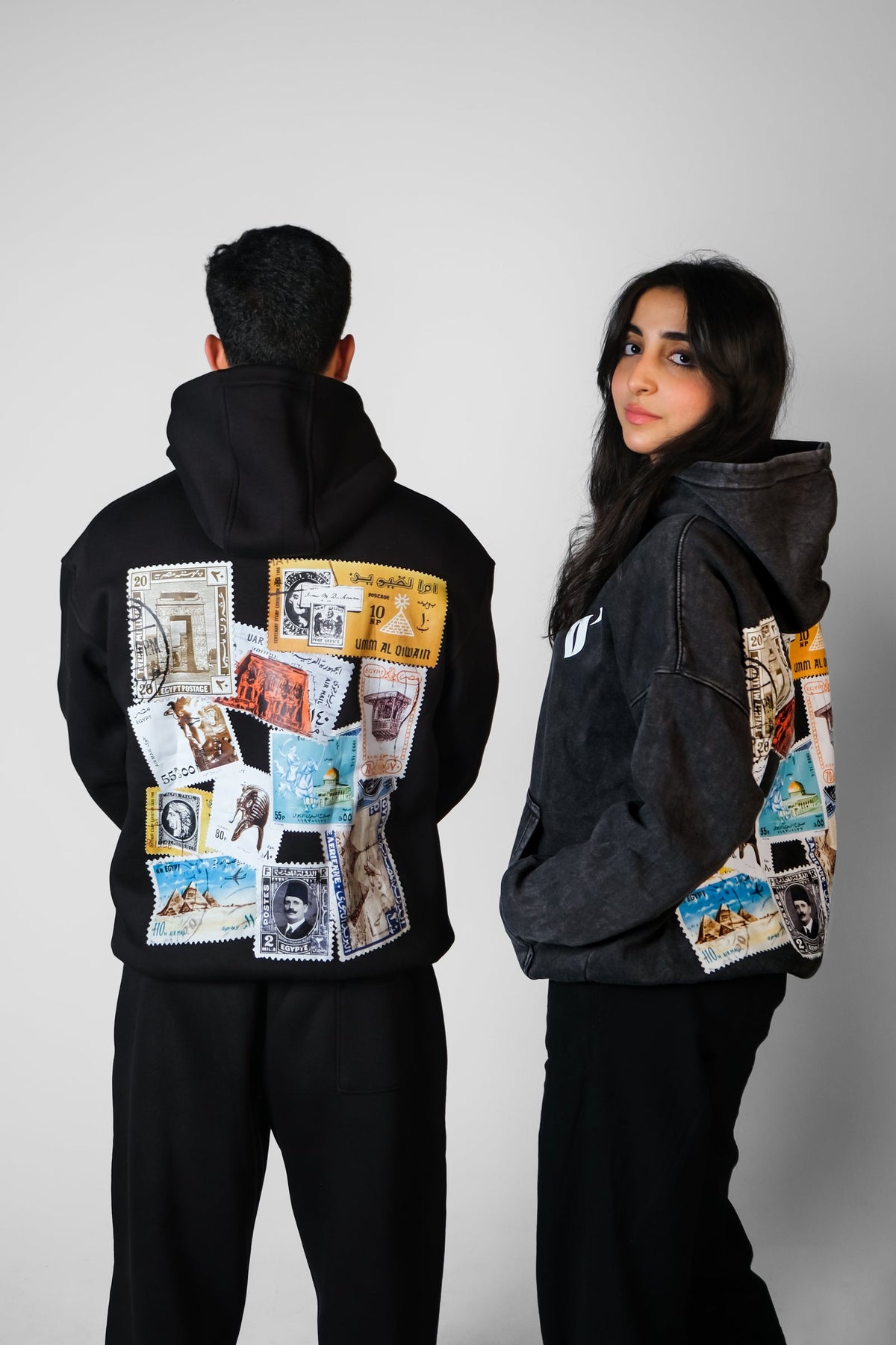 Two QADIM Tawabie washed hoodies in black, vintage Egyptian stamp back prints